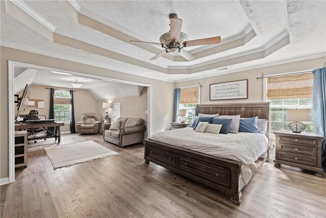 bedroom with a textured ceiling, wood-type flooring, ornamental molding, and ceiling fan