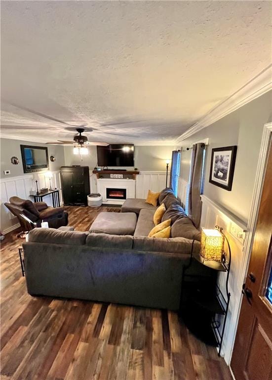 living room with ornamental molding, dark hardwood / wood-style floors, and ceiling fan