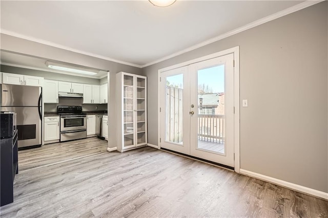 kitchen featuring under cabinet range hood, stainless steel appliances, white cabinetry, french doors, and dark countertops