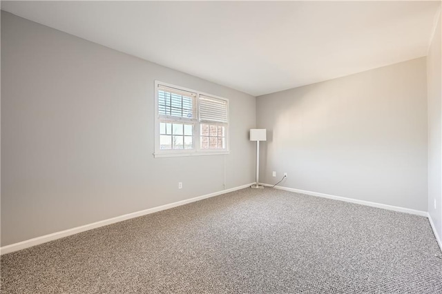 carpeted empty room featuring baseboards