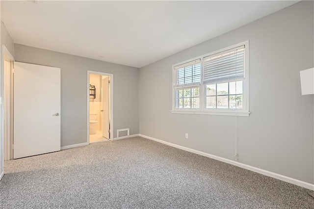 unfurnished bedroom featuring carpet floors, connected bathroom, and baseboards