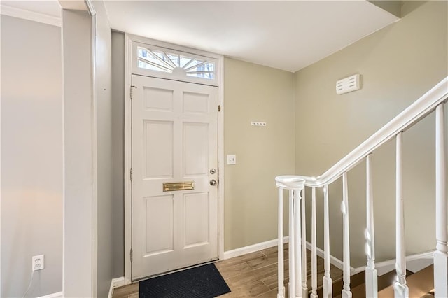 foyer featuring light wood finished floors, stairway, and baseboards