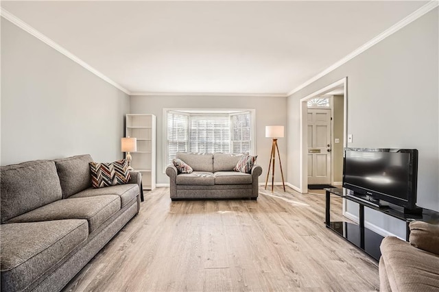 living room with ornamental molding, light wood-style flooring, and baseboards