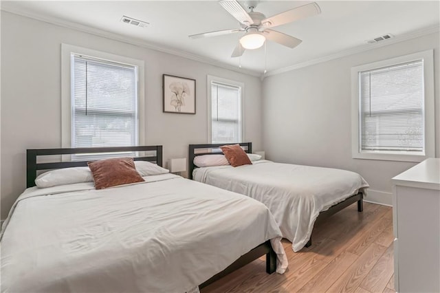 bedroom with ceiling fan, ornamental molding, and light hardwood / wood-style floors