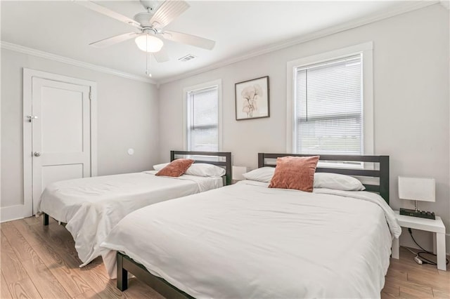 bedroom with crown molding, light hardwood / wood-style floors, and ceiling fan