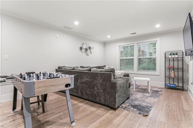 living room with ornamental molding and light hardwood / wood-style floors