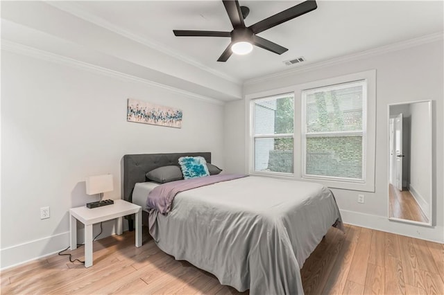 bedroom with ceiling fan, ornamental molding, and light wood-type flooring