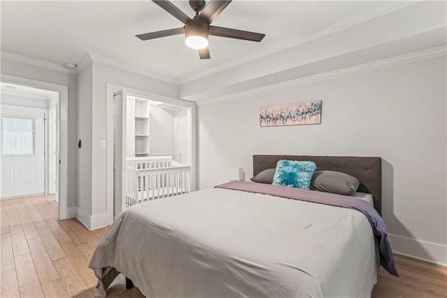 bedroom with ornamental molding, ceiling fan, and light wood-type flooring