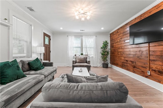 living room featuring crown molding, light hardwood / wood-style floors, and wood walls