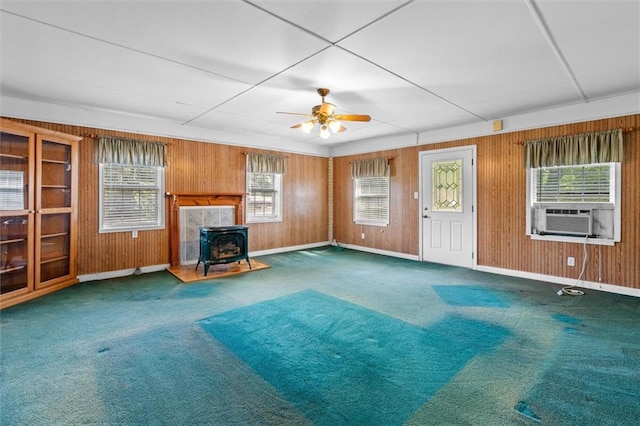 6674 Cowan Mill Rd, Winston, GA 30187 - unfurnished living room with a wood stove, carpet floors, cooling unit, a ceiling fan, and wooden walls