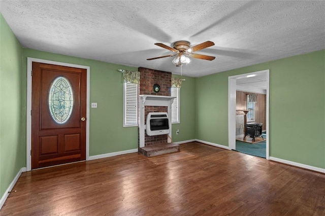 6674 Cowan Mill Rd, Winston, GA 30187 - entrance foyer with heating unit, wood finished floors, ceiling fan, a textured ceiling, and a brick fireplace