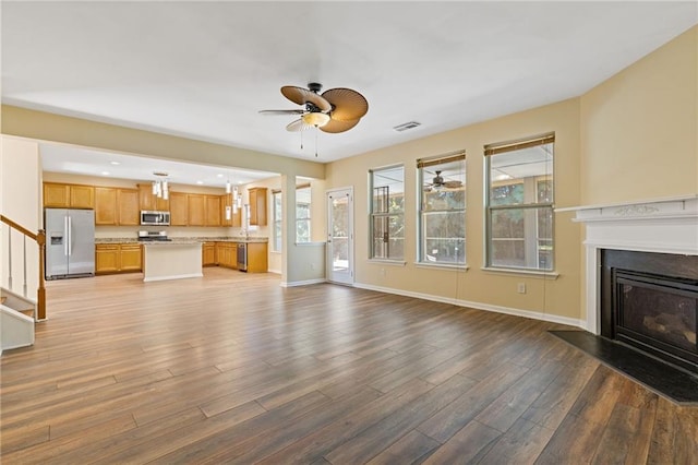 unfurnished living room with light hardwood / wood-style floors and ceiling fan