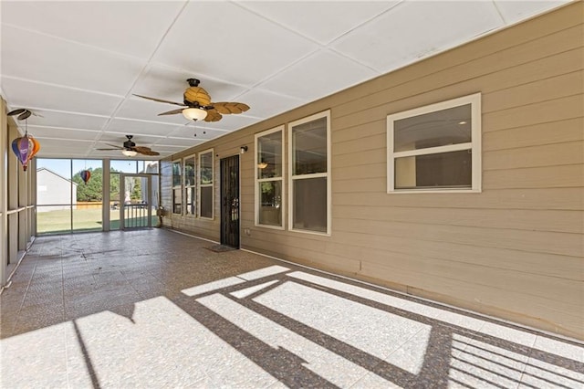 unfurnished sunroom featuring ceiling fan