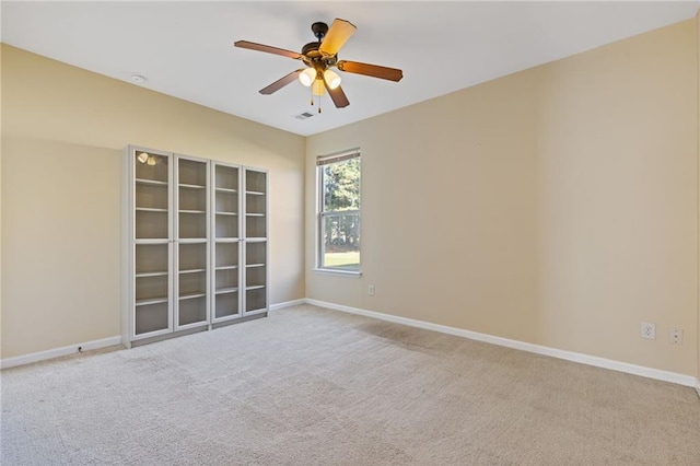 carpeted spare room with ceiling fan