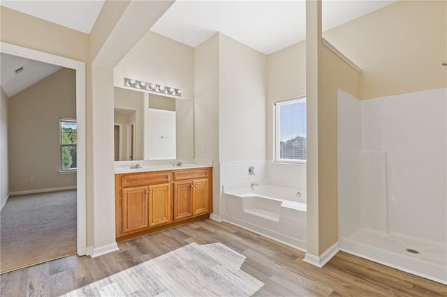 bathroom with vanity, lofted ceiling, independent shower and bath, and wood-type flooring