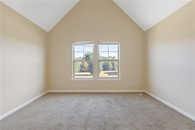 carpeted spare room featuring high vaulted ceiling