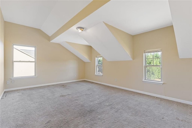 bonus room with lofted ceiling, light carpet, and plenty of natural light