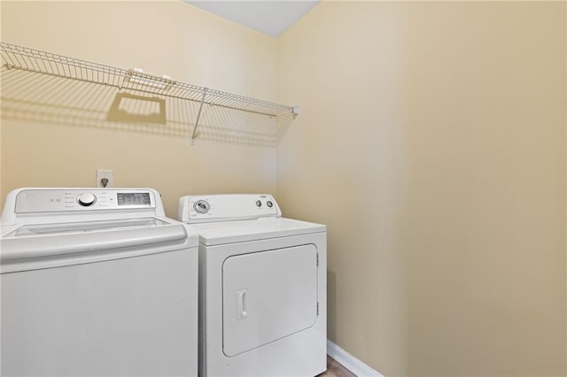 clothes washing area featuring washer and clothes dryer and hardwood / wood-style flooring