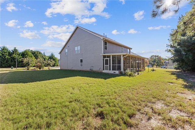 rear view of property with a lawn and a sunroom