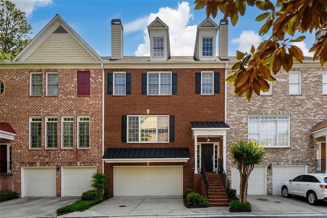 view of front facade with an attached garage, brick siding, a chimney, and driveway