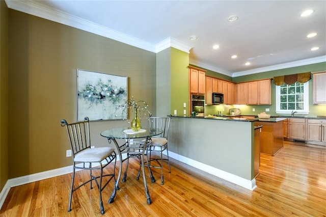 kitchen with oven, black microwave, light wood-style floors, ornamental molding, and dark countertops