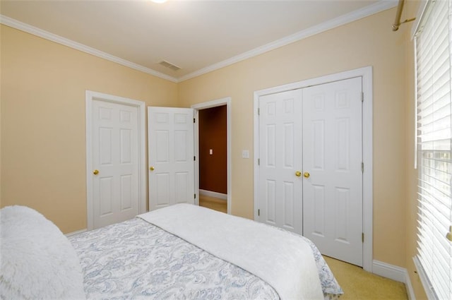 bedroom with light carpet, crown molding, baseboards, and a closet