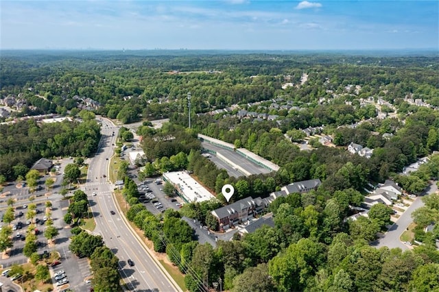 drone / aerial view of a heavily wooded area and a main thoroughfare