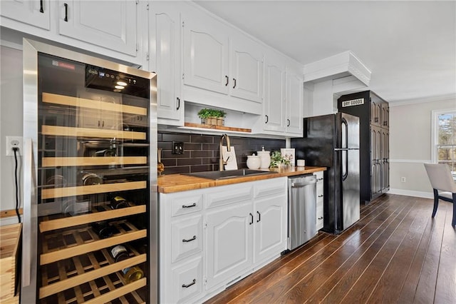 5422 Hill Rd SW, Powder Springs, GA 30127 - kitchen featuring beverage cooler, stainless steel dishwasher, wooden counters, a sink, and ornamental molding