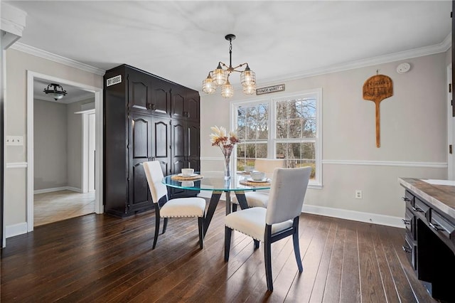 dining space featuring crown molding, dark wood-type flooring, and an inviting chandelier