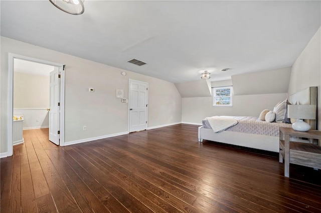 bedroom with dark wood-type flooring and lofted ceiling