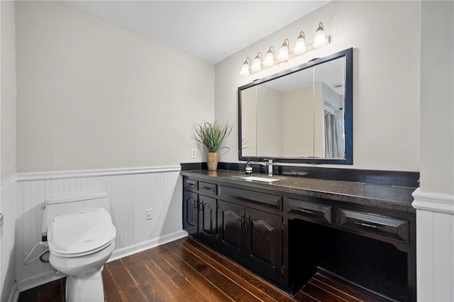 bathroom with wood-type flooring, toilet, and vanity