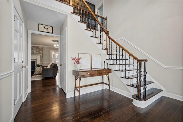 stairs with hardwood / wood-style flooring, a fireplace, and ornamental molding