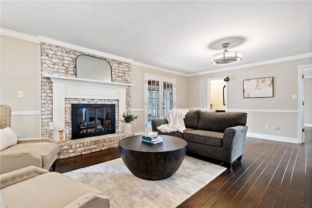 living room featuring crown molding, a brick fireplace, dark hardwood / wood-style flooring, and french doors