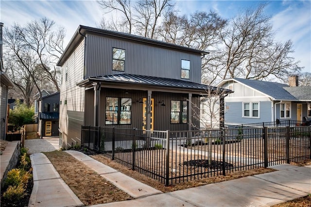 view of front of property featuring a fenced front yard, metal roof, and a standing seam roof