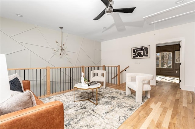 living area featuring a notable chandelier, attic access, and wood finished floors