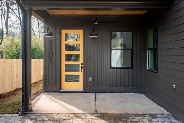 entrance to property featuring fence and board and batten siding