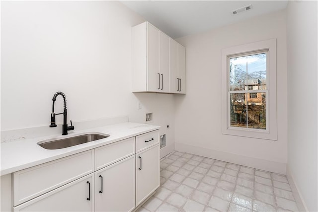 clothes washing area with light floors, visible vents, hookup for an electric dryer, cabinet space, and a sink