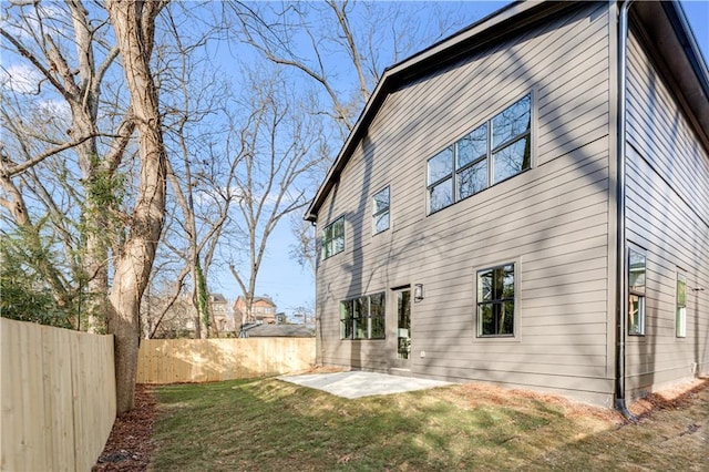 rear view of property with a lawn, a patio, and a fenced backyard