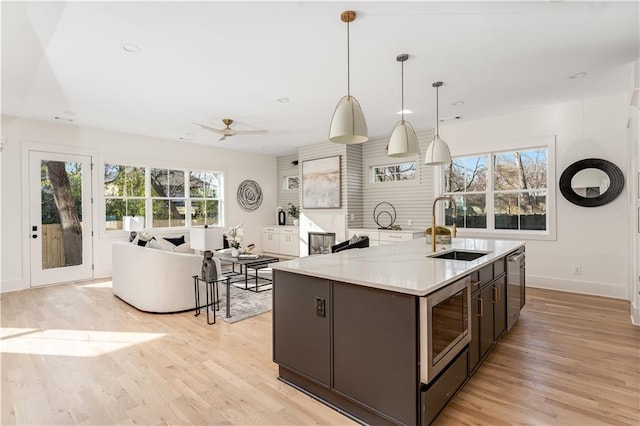 kitchen featuring light countertops, light wood-style flooring, appliances with stainless steel finishes, and a sink