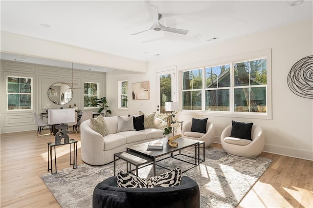 living room featuring visible vents, a ceiling fan, light wood-type flooring, and baseboards