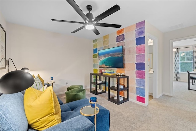 living room with visible vents, baseboards, an accent wall, and light colored carpet