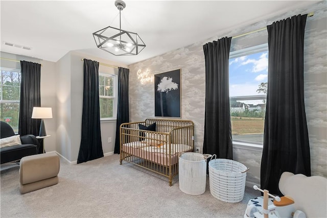 carpeted bedroom featuring wallpapered walls, baseboards, a nursery area, and multiple windows