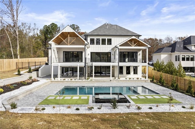 rear view of property featuring a patio area, a fenced in pool, and a balcony