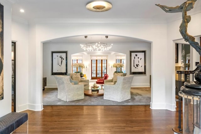 living room with baseboards, arched walkways, dark wood-type flooring, and ornamental molding