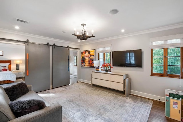 living room with a barn door, crown molding, visible vents, and a wealth of natural light