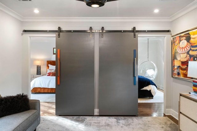 interior space with a barn door, visible vents, and ornamental molding