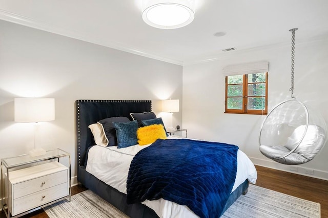 bedroom with baseboards, dark wood finished floors, visible vents, and crown molding