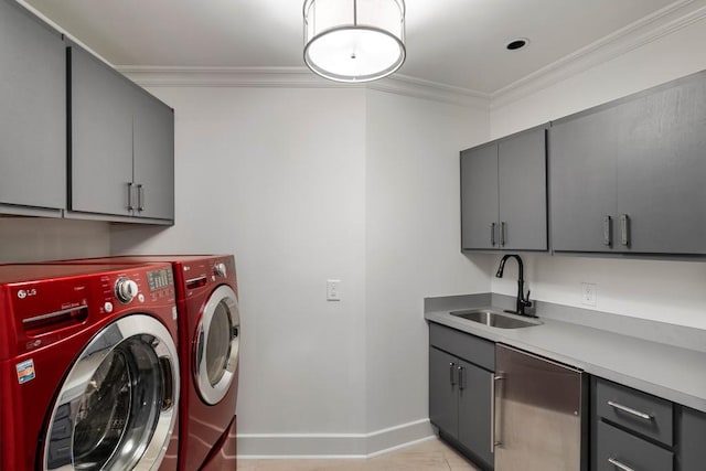 washroom with washing machine and dryer, a sink, baseboards, ornamental molding, and cabinet space