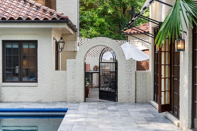 view of gate with a patio