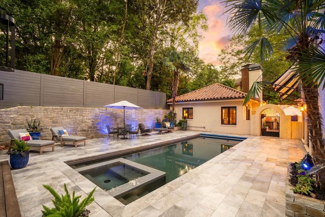 pool featuring a fenced backyard, a patio, and an in ground hot tub